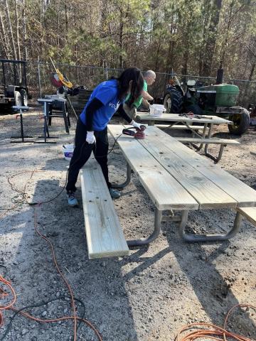 Volunteers working on picnic tables.
