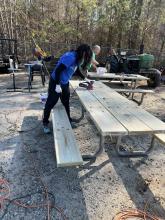 Volunteers working on picnic tables.